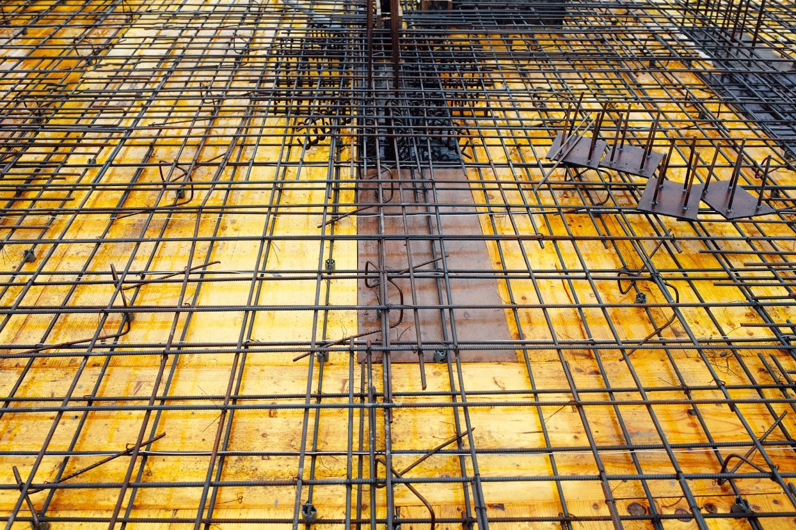 A construction site shows a yellow vapor barrier installed for use under concrete slabs.